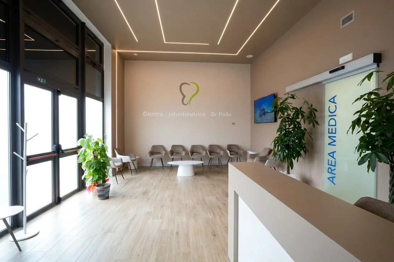 Il bancone dell'accoglienza e il logo a parete dello studio dentistico di Via Carducci a Ghezzano, Pisa