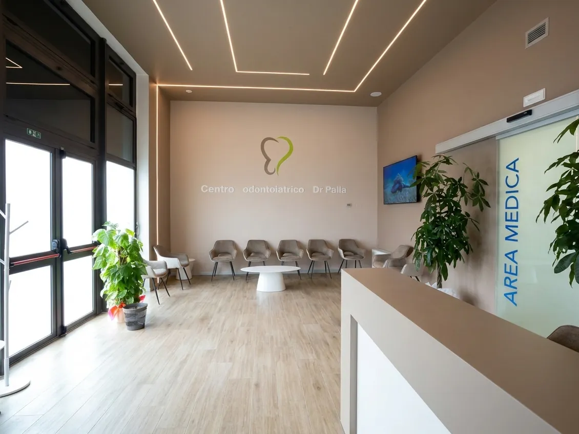 Il bancone dell'accoglienza e il logo a parete dello studio dentistico di Via Carducci a Ghezzano, Pisa